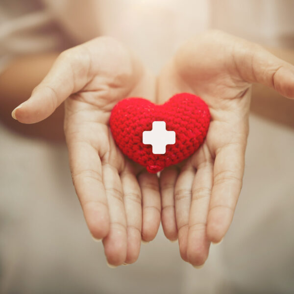 Hand giving red heart for help blood donation healthcare together share love to fight disease concept.